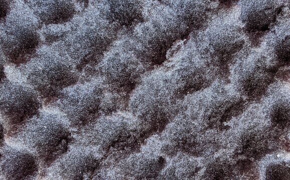 Macro texture of dark grey acoustic foam, acoustic panel surface detail.