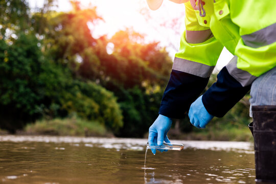 Field worker collecting source water sample to assess quality and safety for drinking water treatment.
