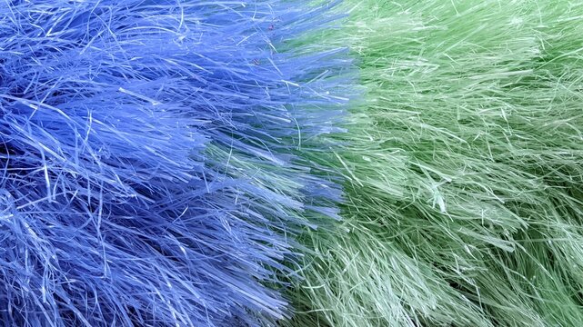 ​Close-up texture of blue and green synthetic plastic duster fibers background