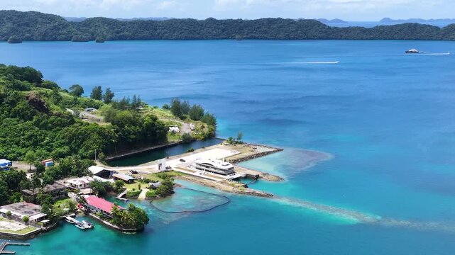 Aerial view of tropical island coastline with turquoise water and boat docks in Palau.