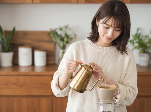 自宅のキッチンで真剣にコーヒーをドリップする女性