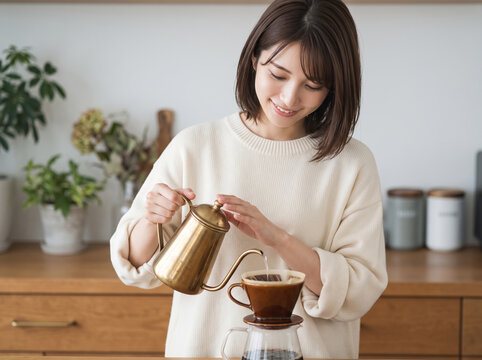 自宅のキッチンでハンドドリップコーヒーを淹れる女性