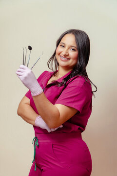Smiling dental worker holding instruments for oral care