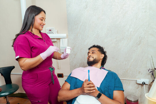 Dental professional instructing patient on proper flossing technique