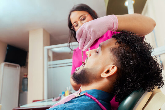 Dentist examining patient mouth in dental clinic