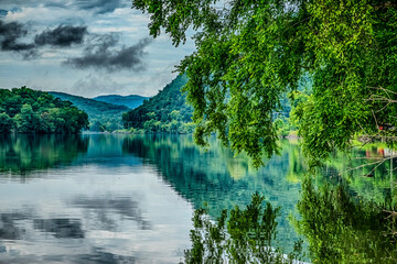 Calm lake water reflecting trees and clouds near the Tail of the Dragon North Carolina