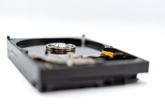 Open hard disk drive showing magnetic platter spindle actuator components isolated white background representing computer data storage hardware technology