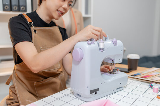 Professional fashion designer measuring fabric, selecting colors and preparing sewing equipment in a modern studio. Creative garment production, textile craftsmanship and apparel design.