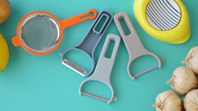 Kitchen tools and fresh vegetables on turquoise background in dynamic overhead clip