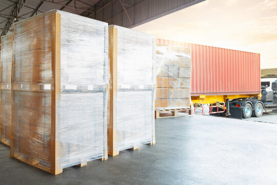Bulk of Package Boxes Wrapped Plastic on Pallets. Truck Loading Dock Warehouse. Cardboard Boxes, Supply Chain, Supplies Goods Shipment. Distribution Warehouse Logistics