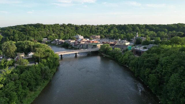 Aerial over the Grand River as it winds through Paris, Ontario, Canada on a warm sunny summer afternoon. Crossing Penman's Dam, the William Street Bridge and over historic downtown Paris. 