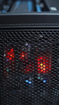 Close-up of a powerful computer tower with glowing red internal fans and blue USB ports