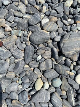 Smooth striped beach pebbles close-up texture