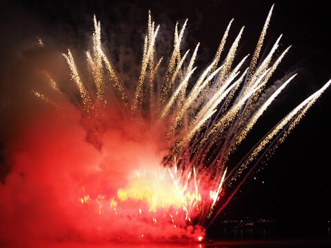 Red and gold fireworks explosion with smoke