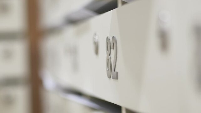 Selective focus close up shot of apartment building mailboxes with number eighty two in modern hallway