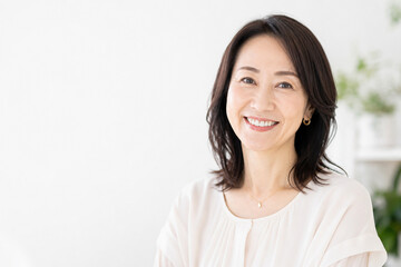 Fototapeta premium 室内で穏やかに微笑む日本人中年女性のポートレート Generative AI