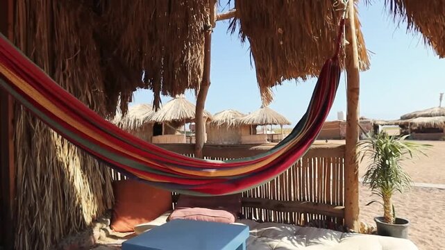 Hammock hanging at the entrance of the hut by the sea