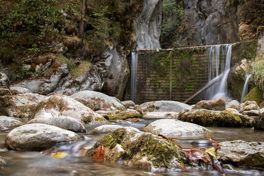 Mountain stream flowing over rocks with small waterfall