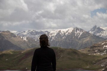 Fototapeta premium Woman observing snowy mountains landscape during outdoor adventure