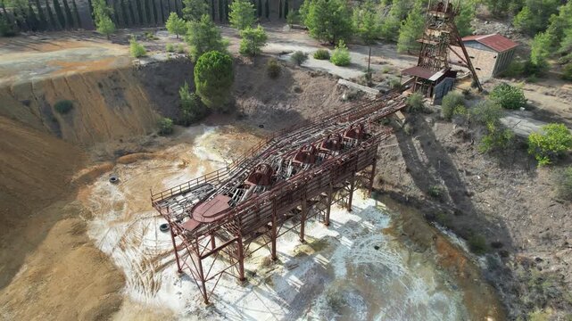 Drone Aerial footage slowly pulling back from the rusty, abandoned structures of the mitsero mine in cyprus