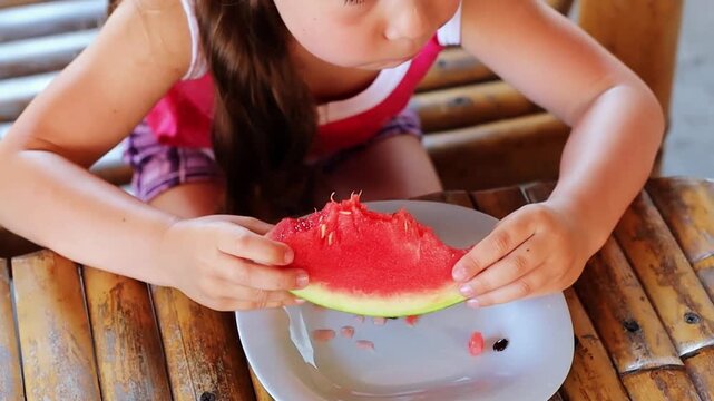 Cute little girl around 5 years old eating tasty juicy watermelon