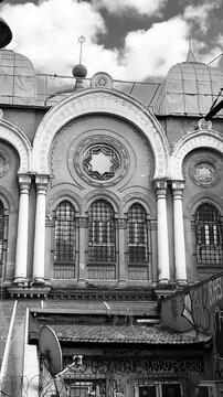  Beautiful historic synagogue building facade with arched entrance and Star of David window in Istanbul. Ancient religious stone architecture design element with decorative dome close up.