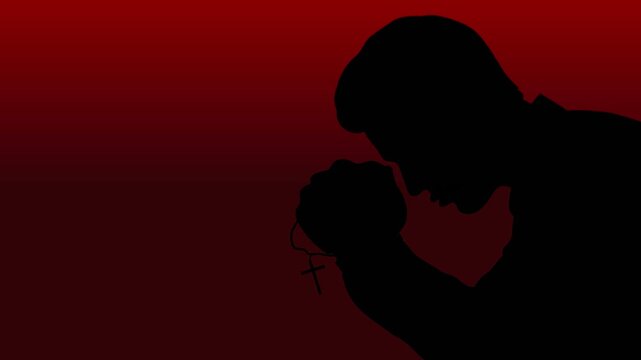 A Christian man kneeling with a cross in his hands and praying for forgiveness