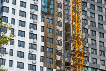 Construction progress on a modern high-rise building in a bustling urban area during a sunny day © beholdereye