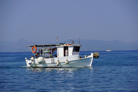 A fishing boat returning in the morning, in Glyfada, Greece