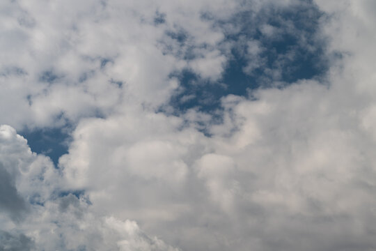Fluffy clouds dance across the bright blue sky during a peaceful afternoon inviting dreams and imagination to flow freely