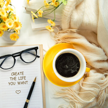 Notebook with create the life you want message inspiring new beginnings and future life planning with yellow cup coffee, warm sunshine.  Goal Life Wellness Concept.