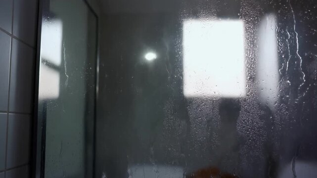 Water droplets and steam on a glass shower door