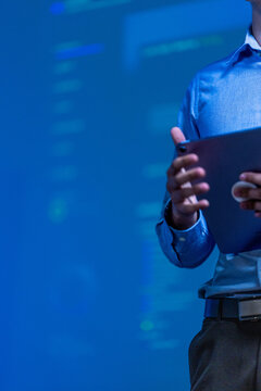A detailed shot of an outstretched finger selecting a panel on screen captures the quiet routine of monitoring work after office hours while critical systems run around the clock