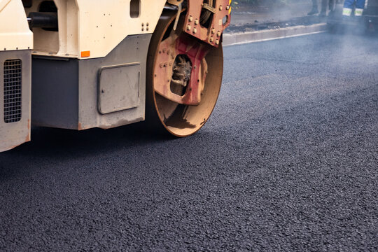 Laying Asphalt Concrete on a City Street During Road Repair in a Metropolis