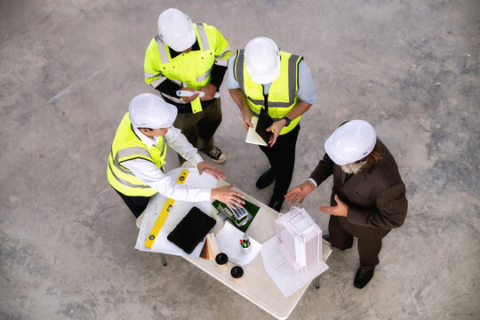 Engineering management team are evaluating construction area to install solar power systems for future green building in city. Concepts of sustainable real estate developers, high angle top view.