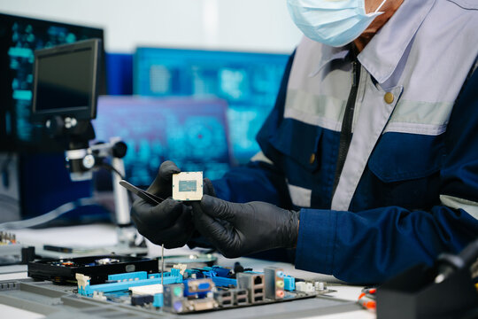 The technician is putting the CPU on the socket of the computer motherboard. electronic engineering electronic repair, electronics measuring