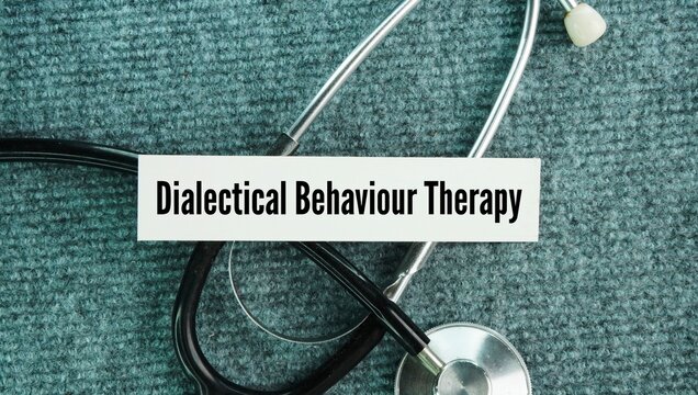 Stethoscope and paper with the words Dialectical behavior therapy DBT. evidence-based type of talk therapy designed to help people manage intense emotions, reduce self-destructive behaviors