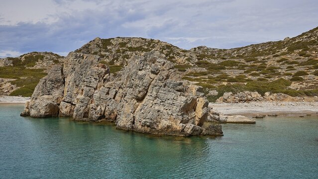 Ragged rocks on a rocky coast with clear water and a barren, overgrown background, boat tour Saria, Saria Island, Karpathos, Dodecanese, Greek Islands, Greece