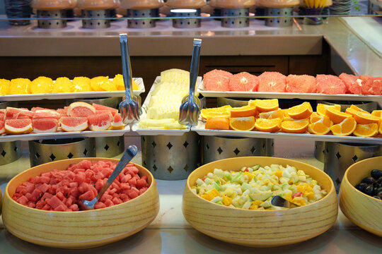 Fresh tropical fruit buffet display with sliced oranges, grapefruit, watermelon, and fruit salad