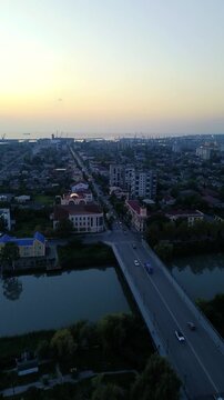 Aerial drone view of the central streets and urban architecture of Poti, Georgia, filmed vertically in 4K on September 15, 2024. The footage shows the city center, streets, buildings, and urban landsc