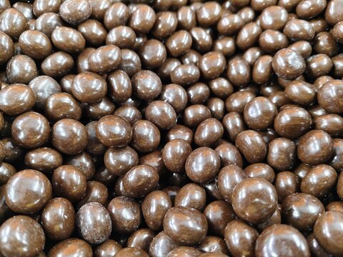 A macro, full-frame background texture of shiny, round brown chocolate candies