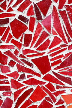 A red mosaic background made of glossy ceramic and glassy tiles. Elegant texture, geometric pattern, abstract composition, and high-gloss red finish.
