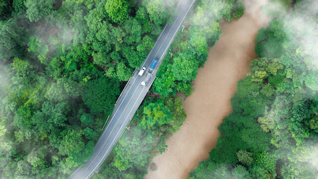 Eco-friendly transport. Aerial view road and green forest, green environment Rainforest landscape with trees and fog - theme conservation,