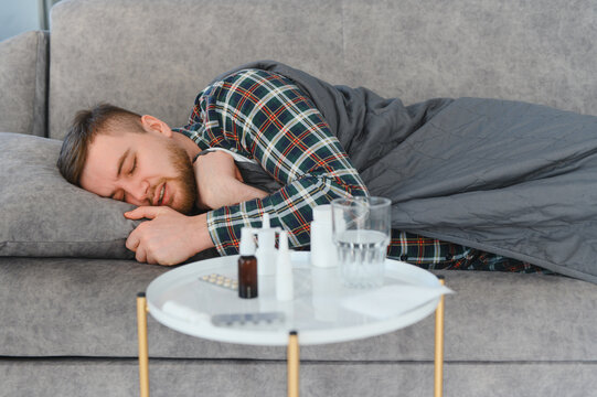 Sick man resting on sofa with flu symptoms
