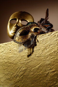 Golden carnival masks on a gold background.
