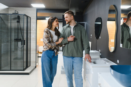 Young couple choosing bathroom sink in home improvement store