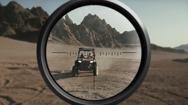 Sniper rifle scope view tracking an off-road buggy vehicle driving through the desert