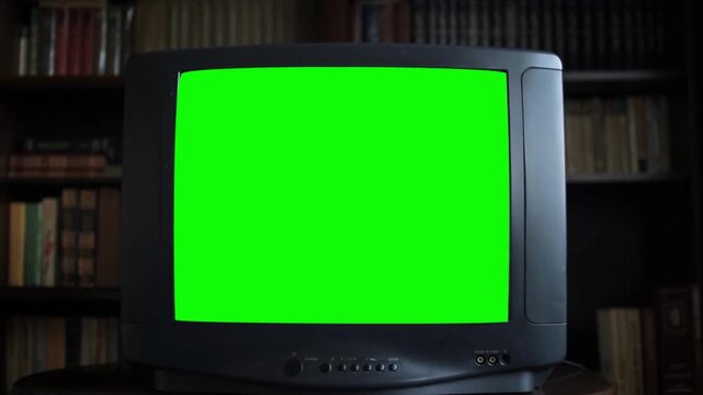 Dated TV Set with Green Screen MockUp Chroma Key Template Display. Nostalgic Retro Nineties Technology. Television screen with blank background in living room. Chromakey for advertising. Vintage noise