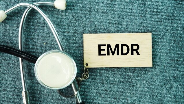 Stethoscope and paper with words Eye movement desensitization and reprocessing EMDR is a talking therapy that helps people heal from the symptoms and emotional distress of disturbing life experiences 