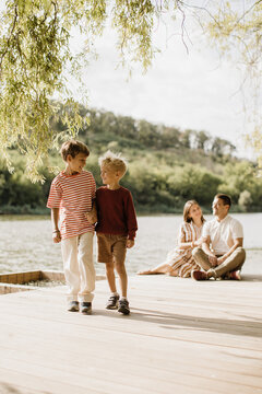 Joyful moment of friendship on a sunny lakeside deck in the afternoon
